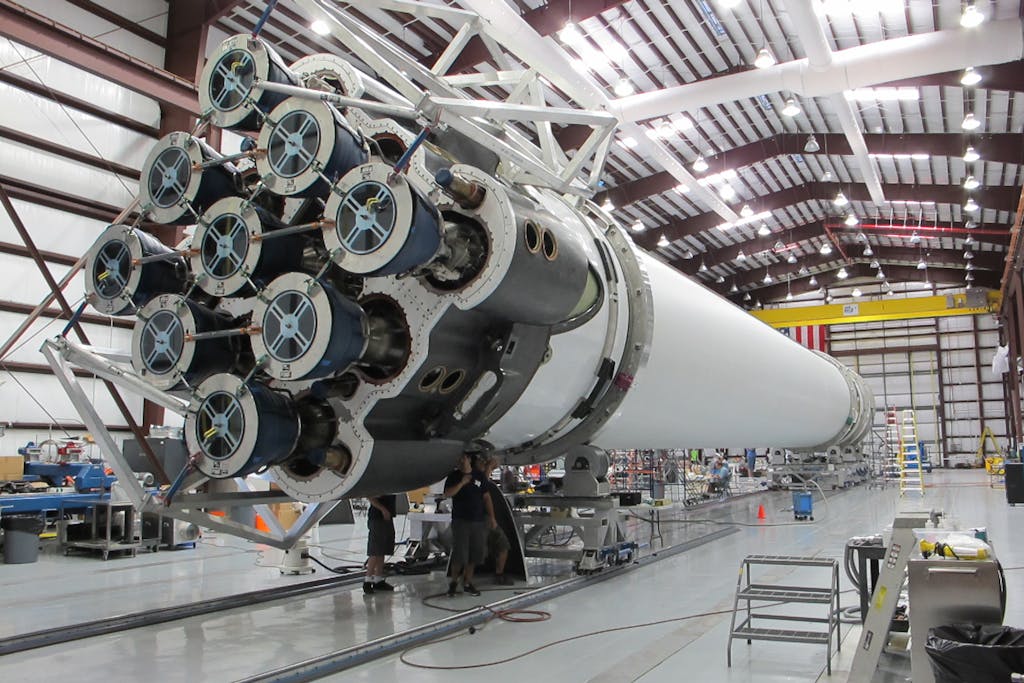 Industries 6 Detailed view of a spacecraft being assembled in an industrial hangar.