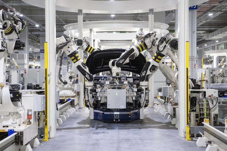 Industries 8 High-tech robots assembling a car in a modern factory setting, showcasing automation.
