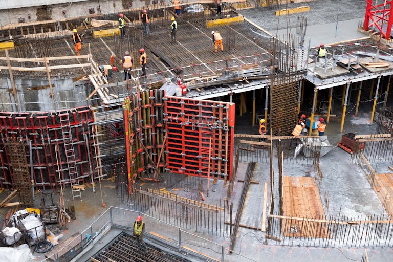 Industries 4 Industrial construction site with workers in high visibility clothing at a steel framework structure.